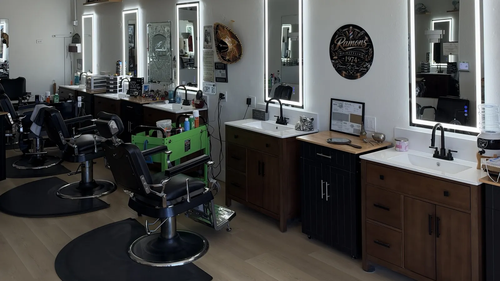 Inside Ramon&rsquo;s Barber Shop: a row of empty barber chairs facing backlit mirrors