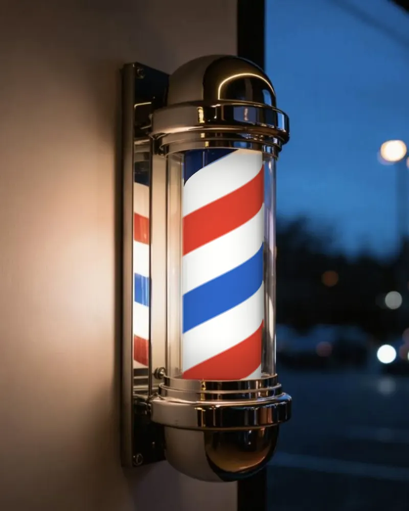 A lit red, white and blue barber pole at dusk