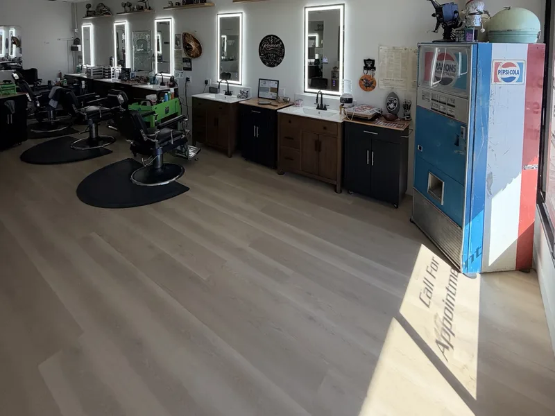 Inside Ramon's Barber Shop: barber chairs, backlit mirrors and a vintage soda machine